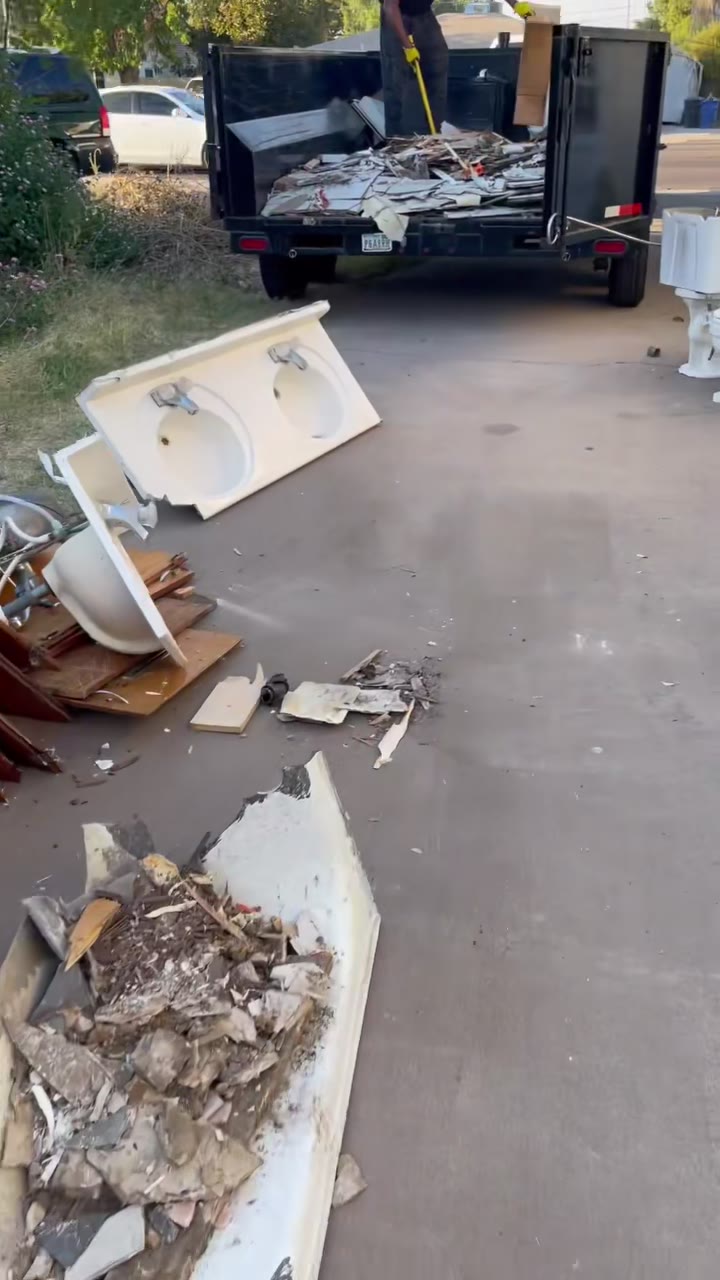 Crew member loading debris into the dump trailer