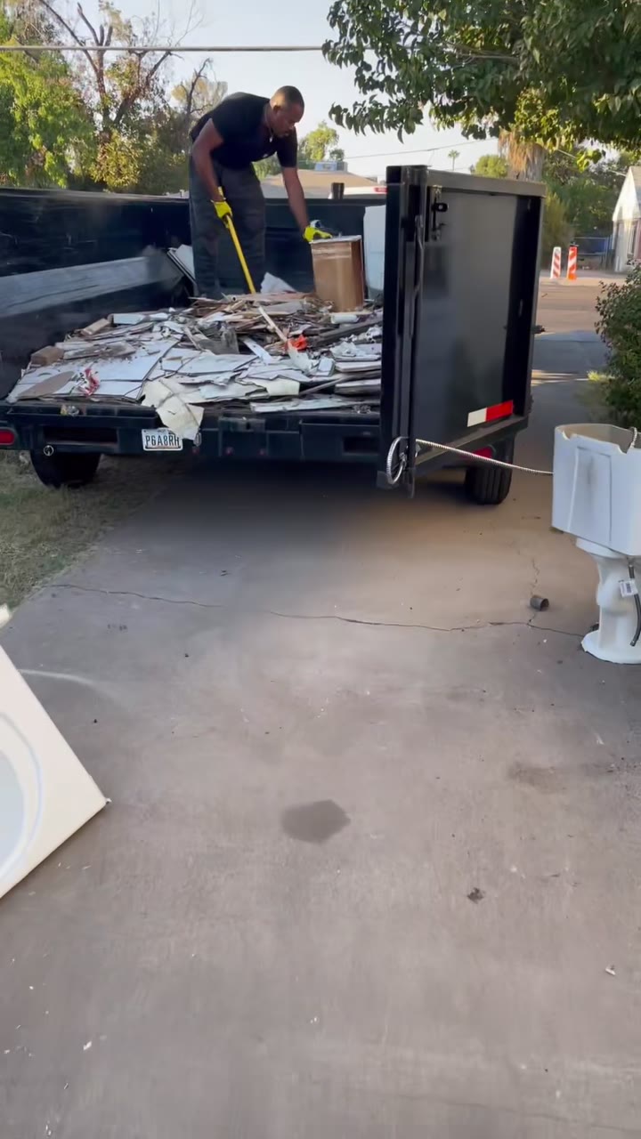 Crew member organizing debris in the trailer